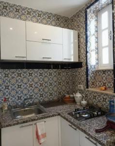 a kitchen with white cabinets and a sink at Dar Haroun Tunis in Tunis