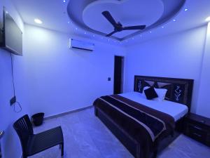 a bedroom with a bed and a ceiling with blue lights at The Redcarmine in New Delhi