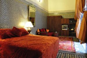 una camera da letto con un letto grande e uno specchio di Riad Au 20 Jasmins a Fes