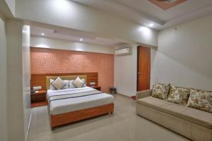 a hotel room with a bed and a couch at Hotel Saineel Residency in Mumbai