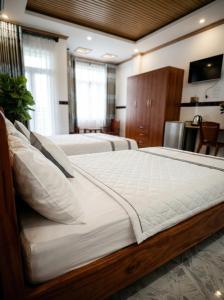 a large bedroom with two beds and a television at CT Morning Hotel in Can Tho