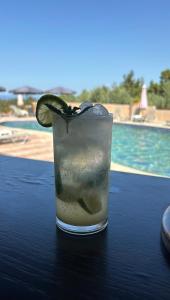 a drink on a table with a slice of lime at Hotel Ilios in Kriopigi