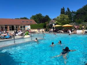 a group of people swimming in a swimming pool at Camping Paradis l'Arada Parc in Sonzay
