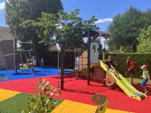 a playground with children playing on a slide at Camping Paradis l'Arada Parc in Sonzay