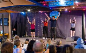 a group of people standing on a stage with their hands in the air at Camping Paradis l'Arada Parc in Sonzay +48 photos