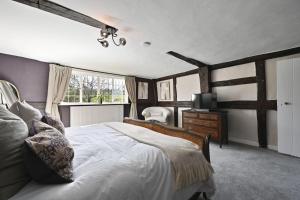 a bedroom with a large bed and a television at Blackham Farm in Hartfield +43 photos