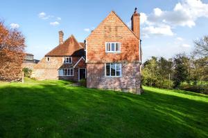 an old brick house on a grassy field at Blackham Farm in Hartfield