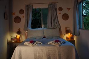 a bedroom with a bed with towels on it at Casa de Mar - Praia do Sagi in Baía Formosa