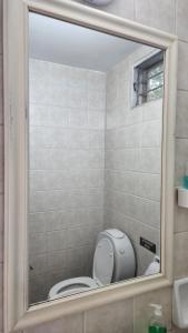a bathroom with a toilet and a mirror at INDIRA Hospedaje Canning in Canning