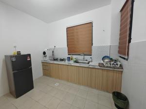 a kitchen with a black refrigerator and a sink at Homestay Amna DShorea in Port Dickson