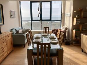 a dining room with a table and chairs with a view at John's Luxury Seafront Apartment in Newcastle +32 photos
