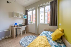 a small bedroom with a bed and a desk at Nemea Appart Hotel Coliseum Amiens Centre in Amiens