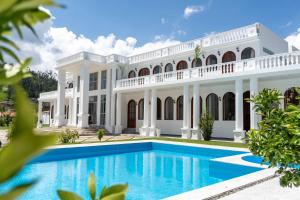 an exterior view of a large white mansion with a swimming pool at Mansión Altamirano - Hotel in Talavera