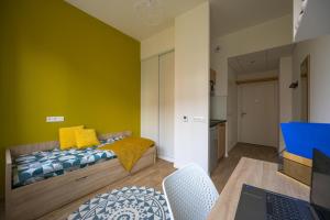 a bedroom with a bed and a table with a laptop at Nemea Appart Hotel Coliseum Amiens Centre in Amiens +28 photos
