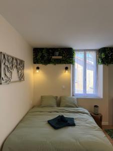 a bedroom with a bed with a hat on it at La Jungle - A71 - Jacuzzi et Cinéma in La Chapelle-Saint-Ursin