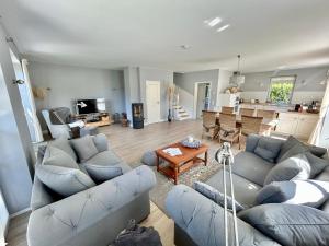 a living room with blue couches and a kitchen at Reetdachhaus Nordstern in Garding
