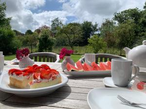 a table with a piece of cake and fruit on it at Reetdachhaus Nordstern in Garding