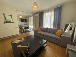 a living room with a couch and a table at Le Sam in Brive-la-Gaillarde