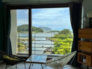 a room with a large window with a view of a lake at maisonde ojolac in Kosŏng-ni