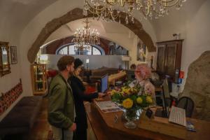a man and a woman standing next to a table with flowers at Altstadt Hotel Stadtkrug in Salzburg
