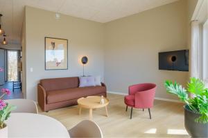 a living room with a couch and a table and chairs at Aalborg Hotel Apartments in Aalborg