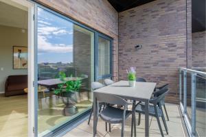 a dining room with a table and chairs on a balcony at Aalborg Hotel Apartments in Aalborg