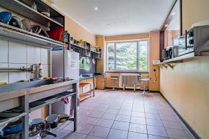a kitchen with a refrigerator and a tile floor at Hotel Garni in Liptovský Mikuláš