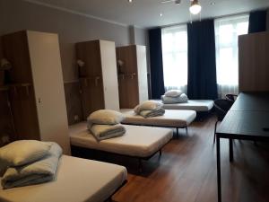 a room with four beds with pillows on them at Hostel Kamienica Rynek 7 in Katowice