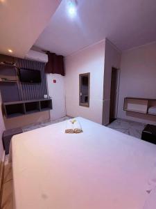 a bedroom with a large bed with two slippers on it at Hotel Nações Unidas in São Paulo