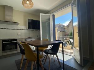 a dining room with a table and chairs in a kitchen at Le Sam in Brive-la-Gaillarde