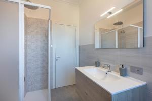 a bathroom with a sink and a shower with a mirror at Lexia Suite in Lesa