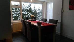 a room with a table with chairs and a window at Carpe Diem in Ommen