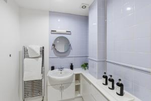 a blue tiled bathroom with a sink and a bath tub at High Quays Apartments - Properties Unique in Newcastle upon Tyne +19 photos