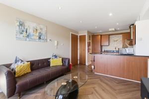 a living room with a couch and a glass table at High Quays Apartments - Properties Unique in Newcastle upon Tyne