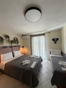 a bedroom with two beds and a large window at Aliki Studios in Parga