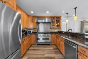 a kitchen with wooden cabinets and a stainless steel refrigerator at Flip Side Oasis Beach House in Pensacola Beach