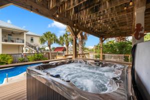 a hot tub on a deck next to a pool at Flip Side Oasis Beach House in Pensacola Beach