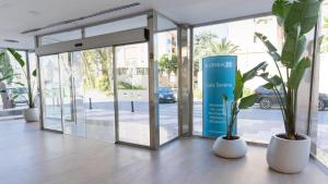 a lobby with three potted plants and a glass door at BLUESEA Costa Serena in Torremolinos