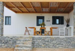 a patio with a table and chairs on a stone wall at Villa Aria in Kampos Paros