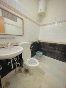 a bathroom with a toilet and a sink at Hotel Har Ki Pauri with terrace Ganga view in Haridwār +25 photos