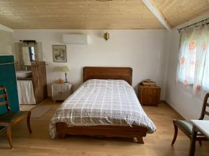 a bedroom with a bed and a table and chairs at Chambre Lucioles in Orniac