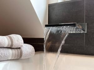 a water fountain in a bathroom with towels at Modernes Apartment in Haiger Allendorf in Haiger +48 photos