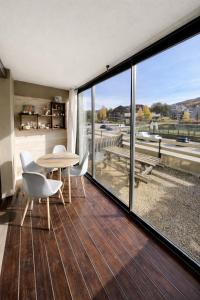 a living room with a table and chairs and windows at Chez Arthur et Léa in La Joue du Loup