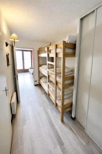 a room with bunk beds and a hallway at Chez Arthur et Léa in La Joue du Loup