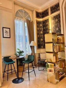 a living room with chairs and a table and a desk at Le Lion dOr Hôtel de Charme et centre ville de Bernay in Bernay