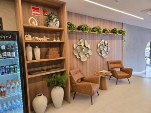 a store with chairs and plants on a wall at Antonius Imperial Hotel in Santo Antônio de Jesus +17 photos