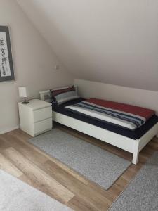 a small bedroom with a bed and a night stand at Ferienwohnung am Dörenberg in Georgsmarienhütte
