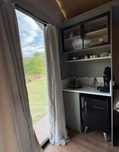 a view of a kitchen and a window in a caravan at Chalé Loft in Lavrinhas