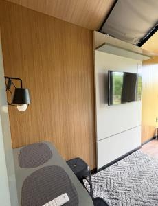 a room with a table and a tv on a wall at Chalé Loft in Lavrinhas