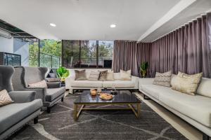 a living room with couches and a coffee table at Ultimate 9BR Lleras Villa W Heated Pool in Medellín